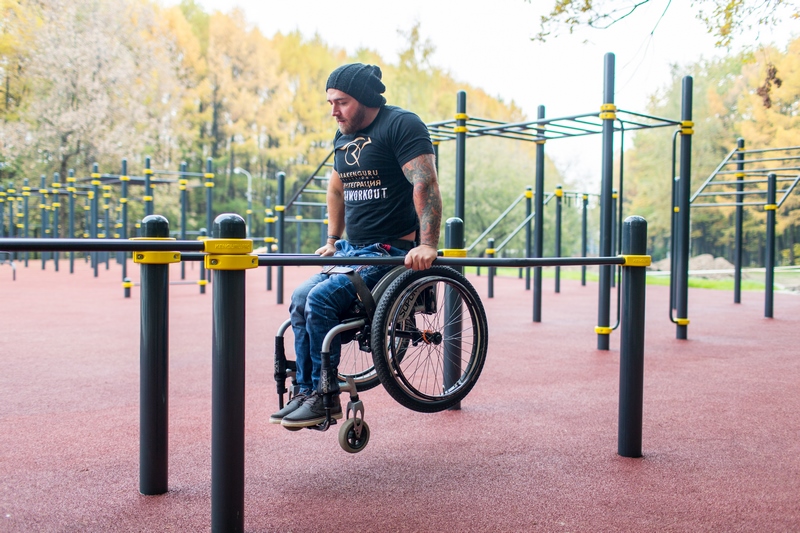 Человек в инвалидной коляске занимается воркаутом
